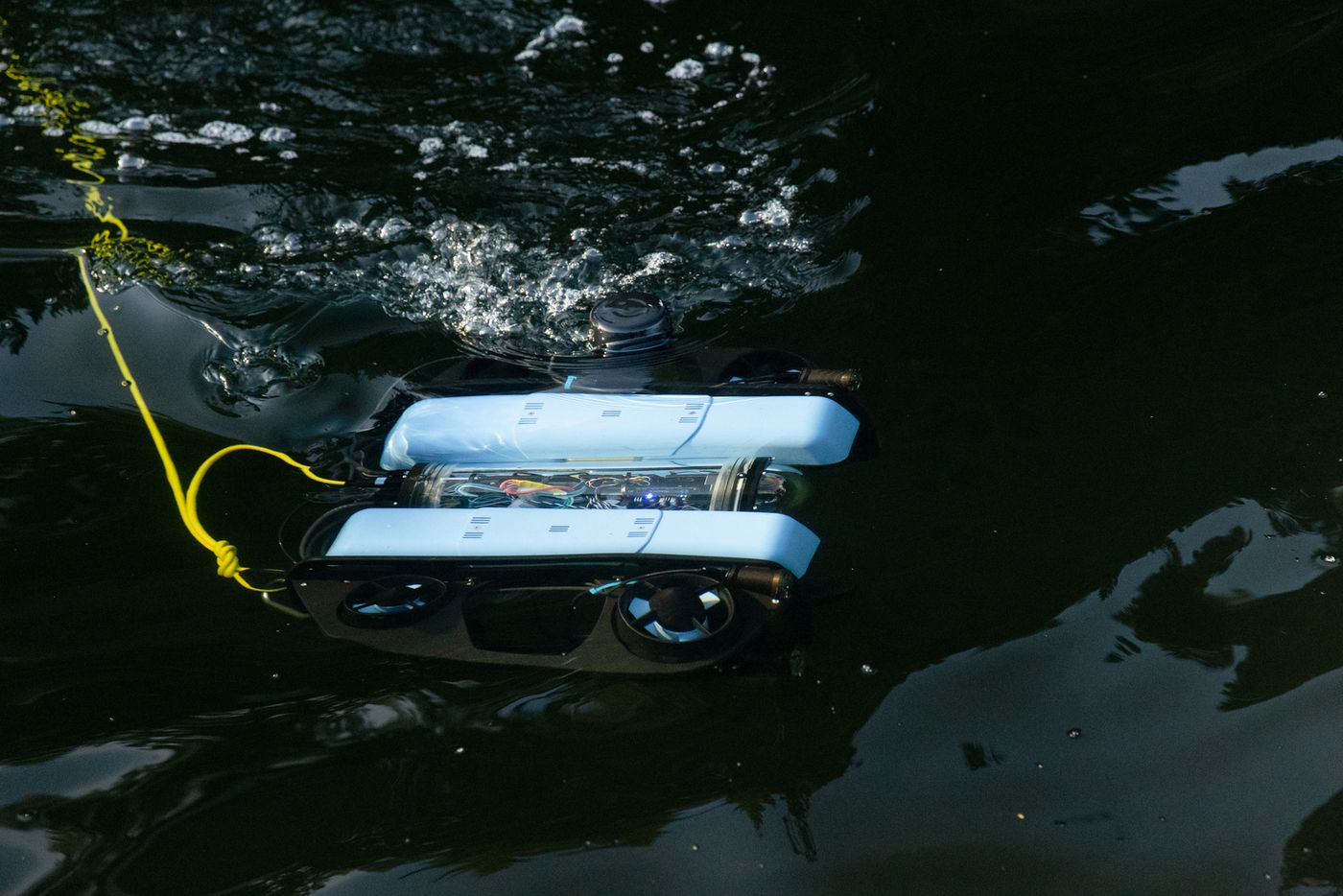 BlueROV2 swimming at the surface in dark water